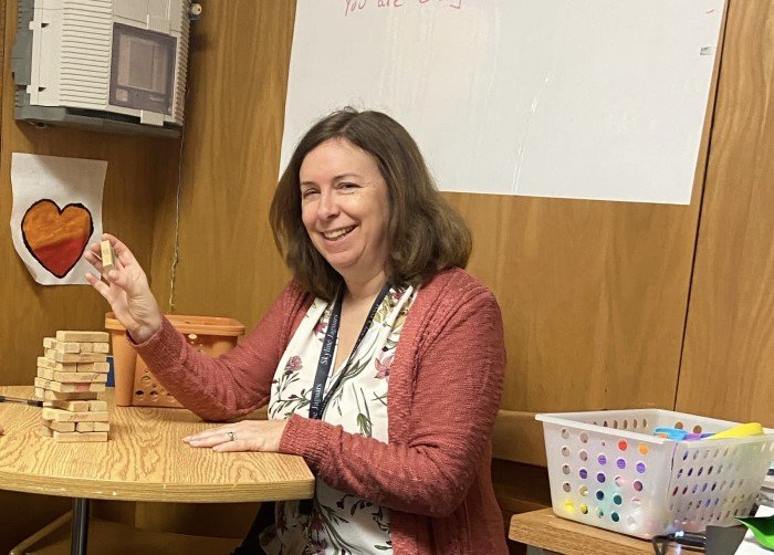 woman at a table playing jenga