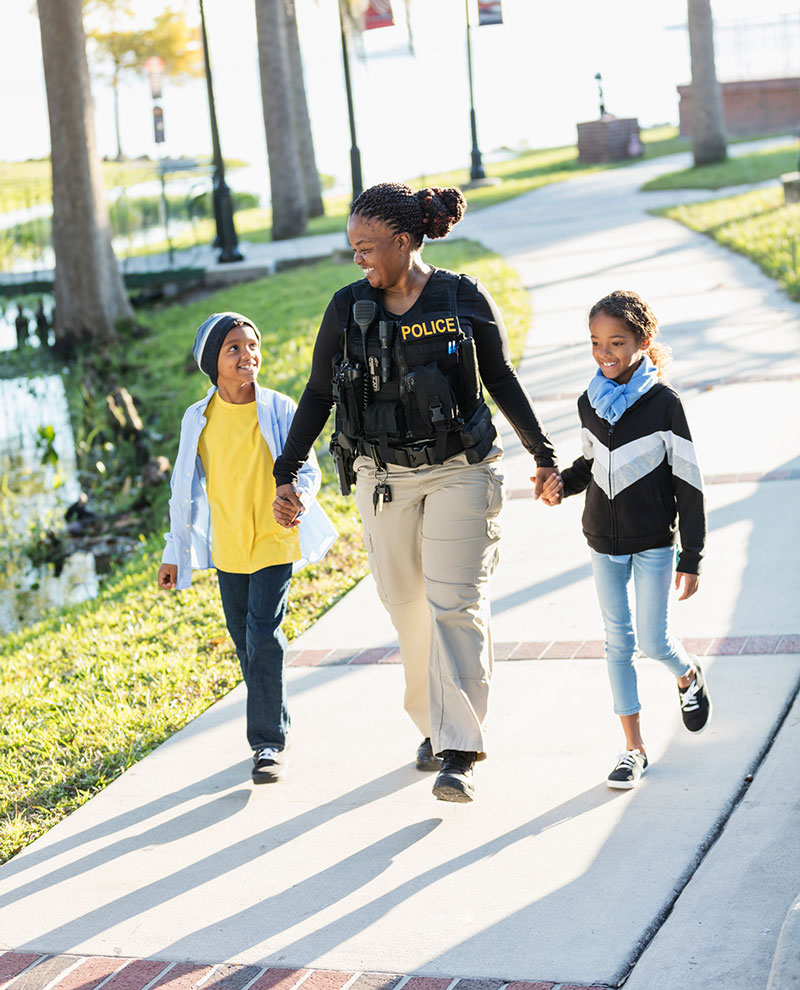 female police offers walking with two children