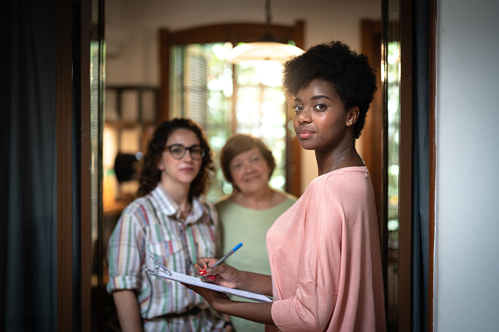 three women smiling from a doorway