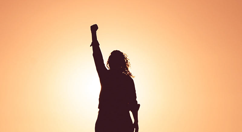 silhouette of a woman with fist in the air