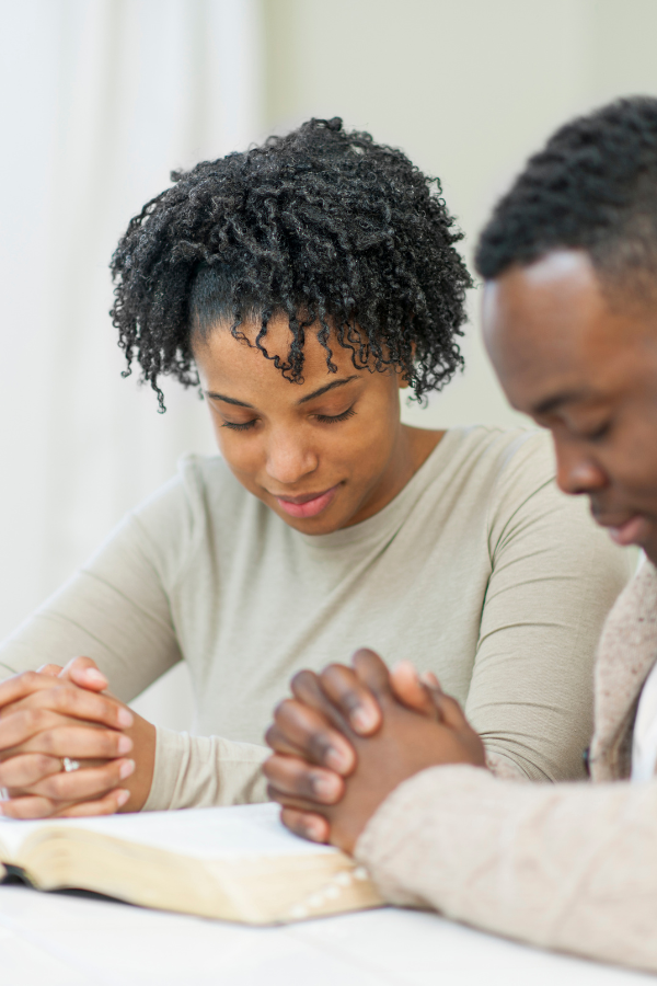 young couple sitting together praying