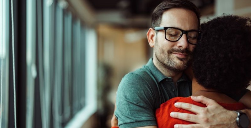 a man hugging another person during a group therapy session