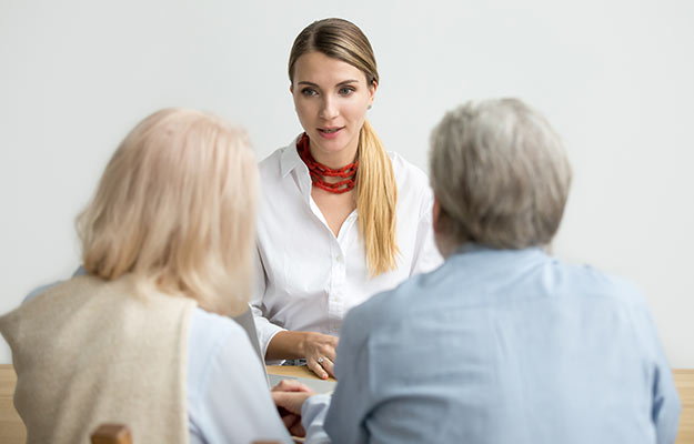 young woman discussing crisis resources with older couple