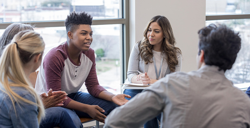 a young man speaks during a youth therapy group session