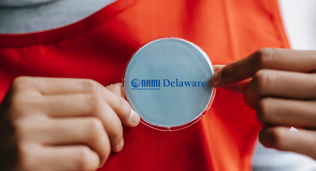 person showing NAMI Delaware badge